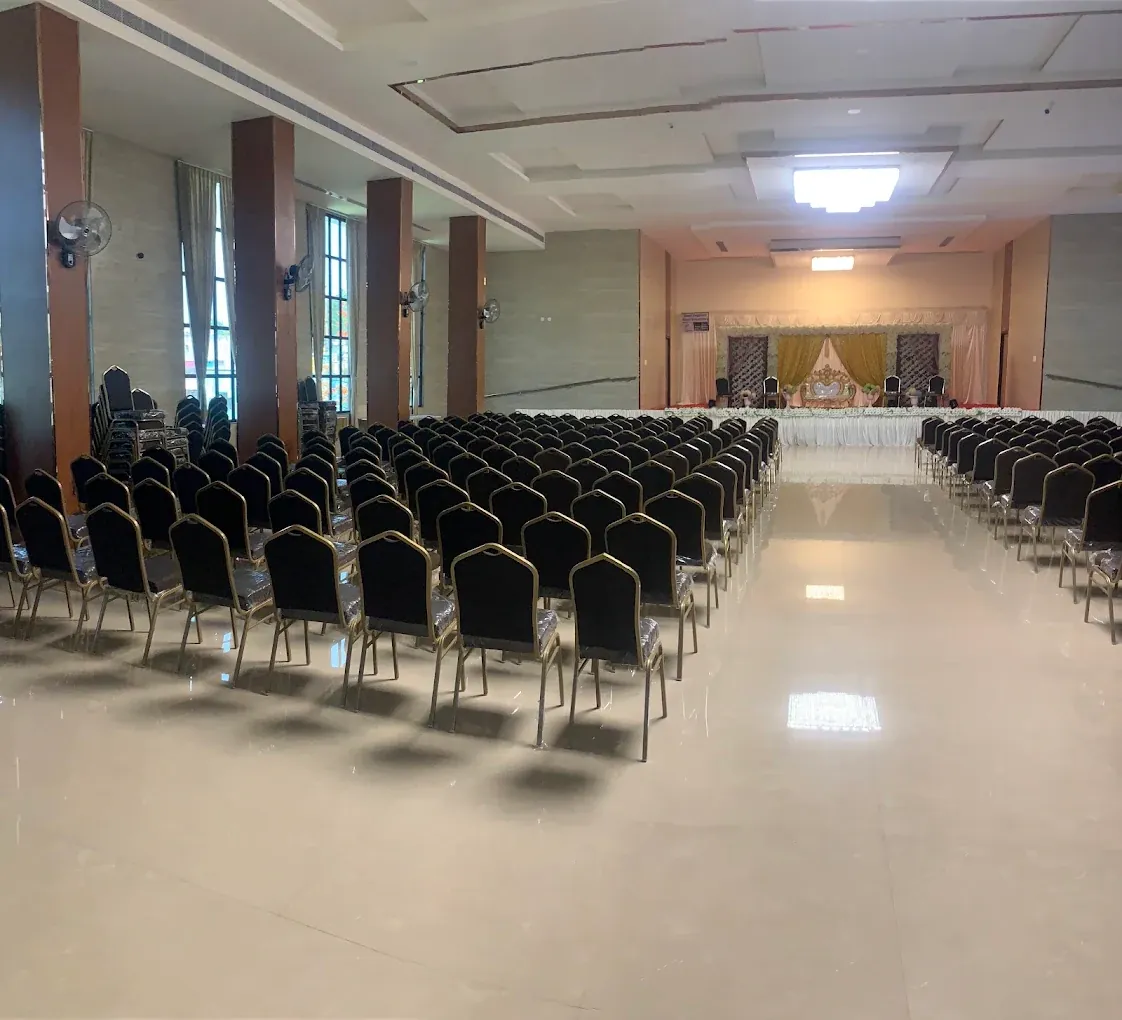 The KPA Palace marriage hall with rows of gold-framed chairs, a polished floor and a decorated stage at the far end