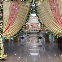 Draped floral arch leading to the stage at a past function