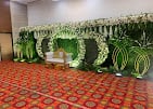 Stage decorated with white flowers and green leaf arches at a past function