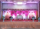 Stage decorated with pink flowers and lights at a past function